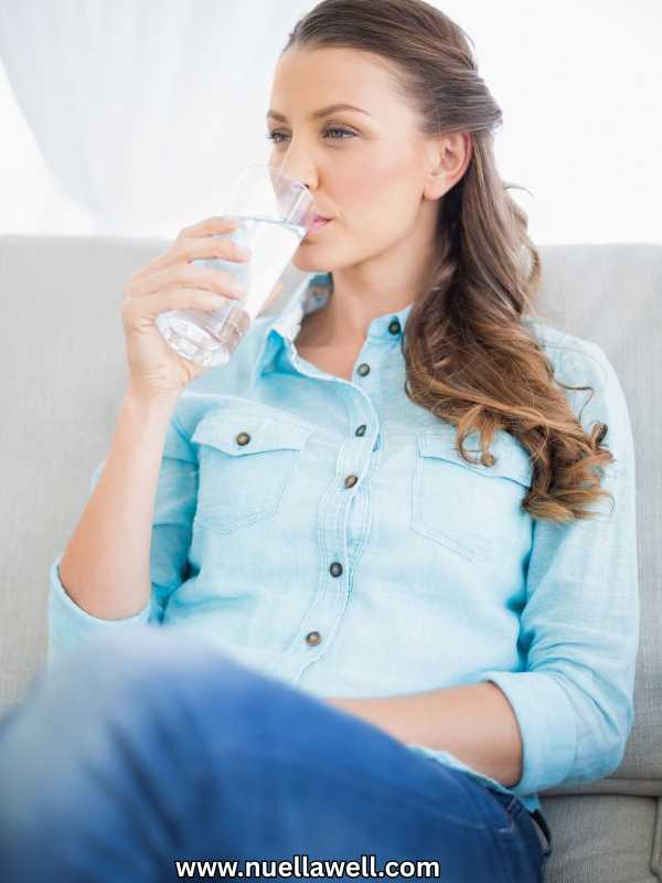 a-calm-woman-sitted-and-drinkig-a-glass-of water