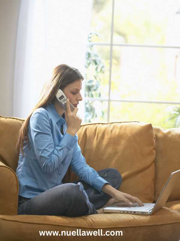 a-mom-answering-phone-call-and-working-on-a-laptop-at-the-same-time