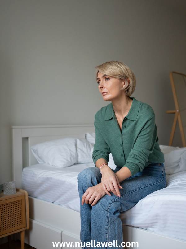 a-woman-sitting-on-the-bed-in-a thoughtful-mood-on-why-moms-ignore-their-own-symptoms