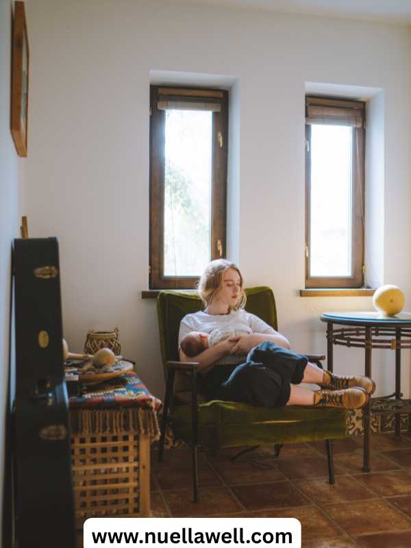 Mom-in-a-nursing-corner-with-burp-cloths-nursing-supplies-water-and-a-cozy-chair.